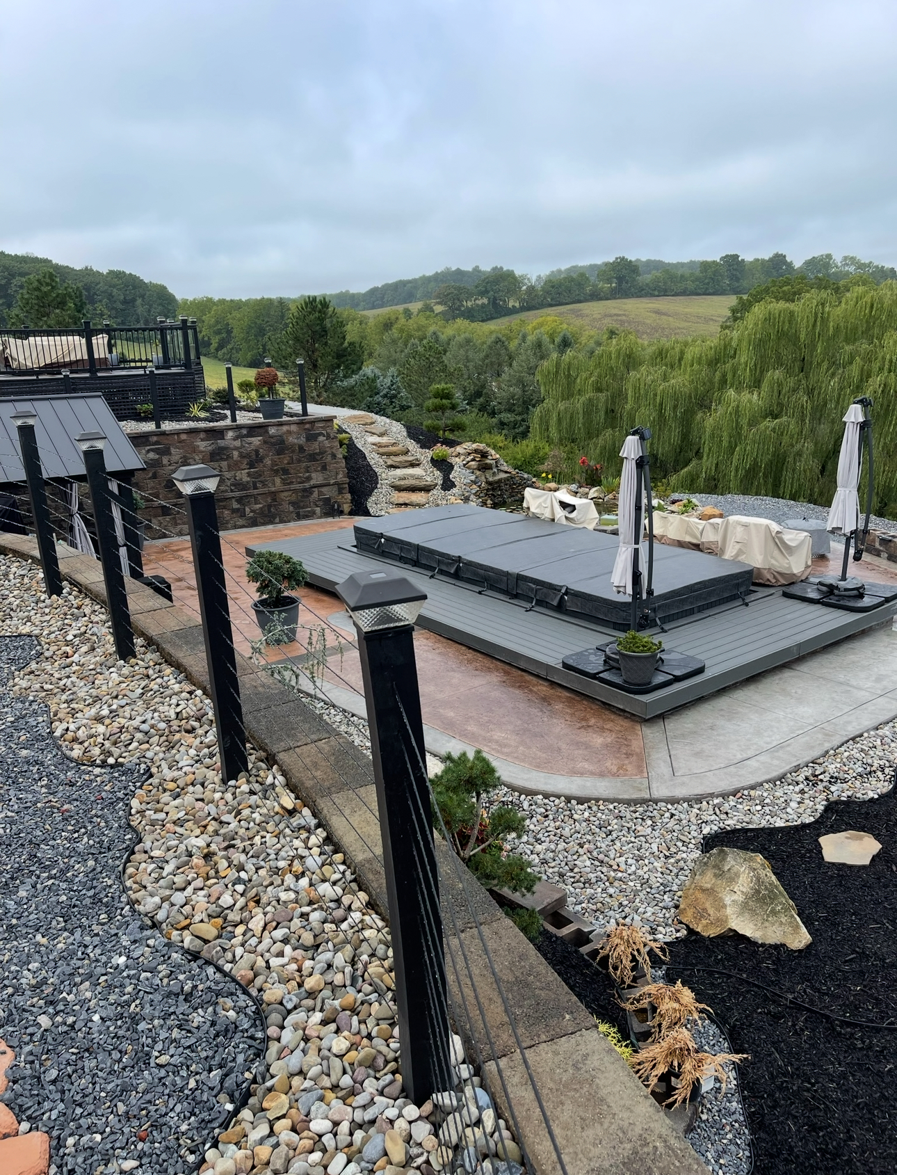 Multi-level outdoor living space with stone retaining walls and scenic views